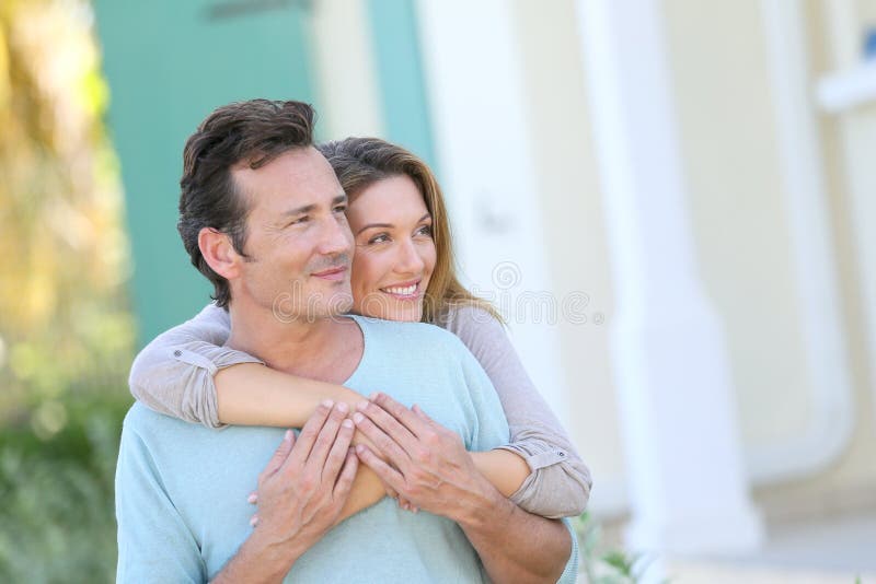 Middle-aged couple in front of the house