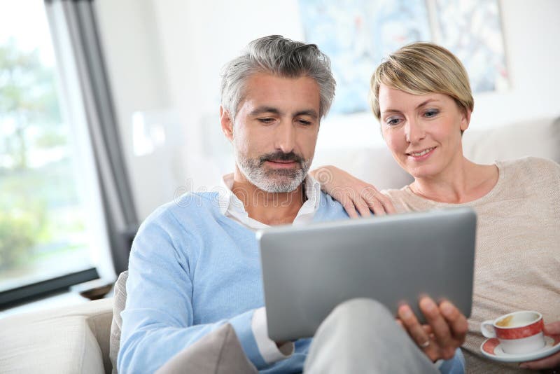 Middle-aged couple on tablet websurfing