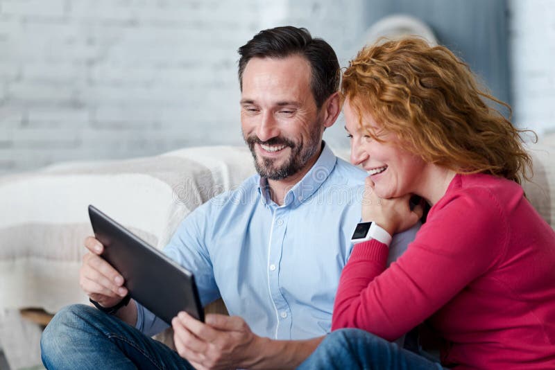 Middle-aged couple using tablet at home