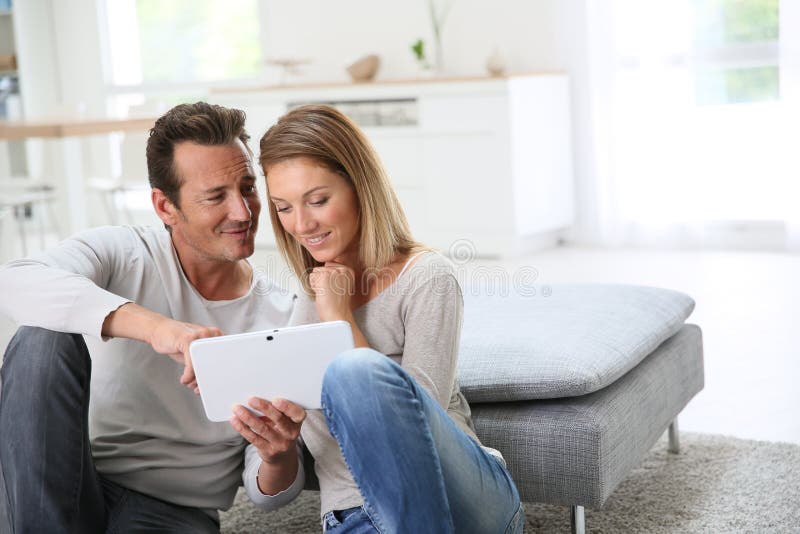 Middle-aged couple websurfing with tablet