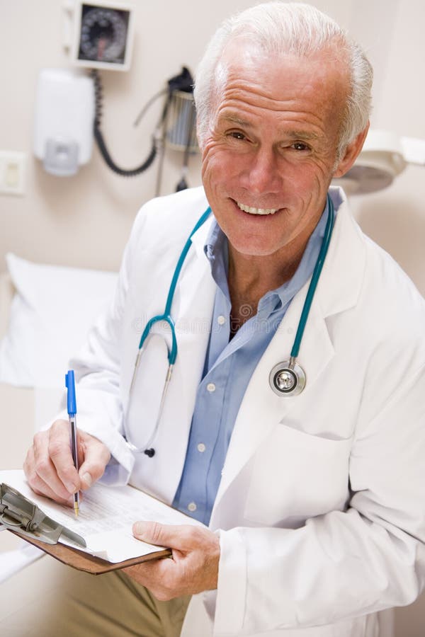 Middle Aged Doctor Writing On His Clipboard royalty free stock image