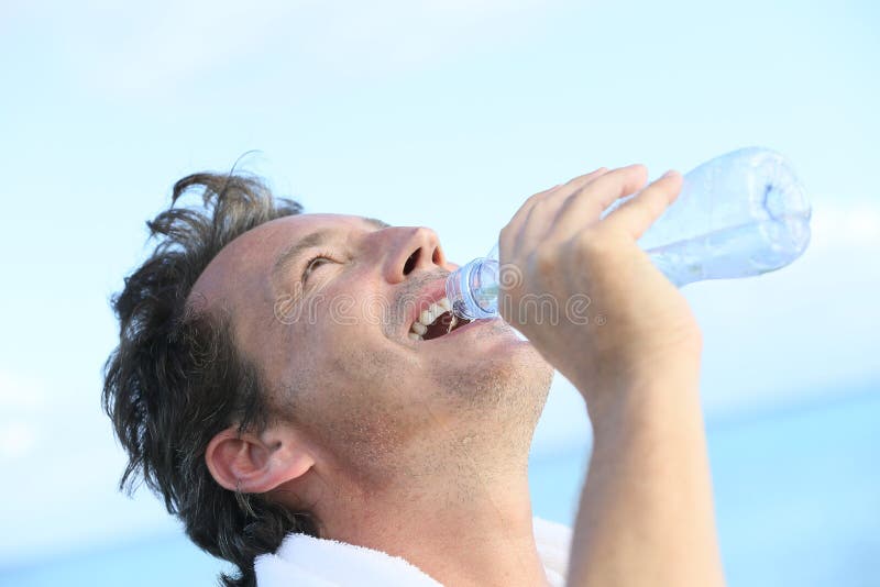 Middle aged man drinking water after work out