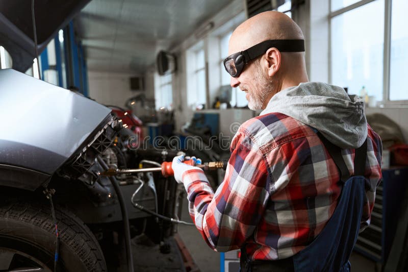 Middleaged Man is Happy To Repair Car after an Accident Stock Image