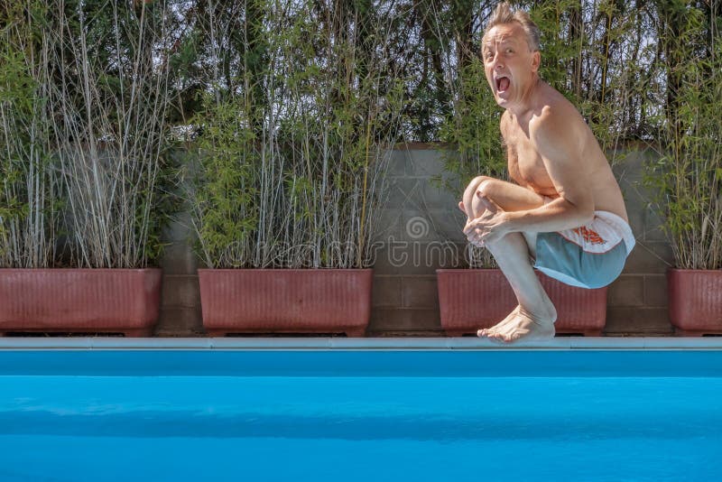 Middle aged white man diving into a swimming pool, cannonball style,with a funny expression