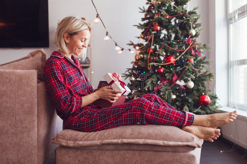 https://thumbs.dreamstime.com/b/middle-aged-woman-opening-her-present-christmas-smiling-cozy-home-pygame-opens-gift-sitting-alone-tree-sofa-263793638.jpg