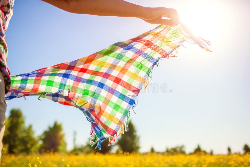 Middle-aged woman walking in spring field at sunset among flowers and holding scarf shaking on wind stock photos Middle-aged woman walking in spring field at sunset among flowers and holding scarf shaking on wind stock photos