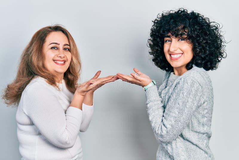 Middle East Mother and Daughter Wearing Casual Clothes Pointing Aside