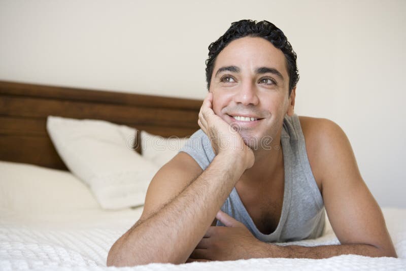 A Middle Eastern man lying on a bed royalty free stock photography
