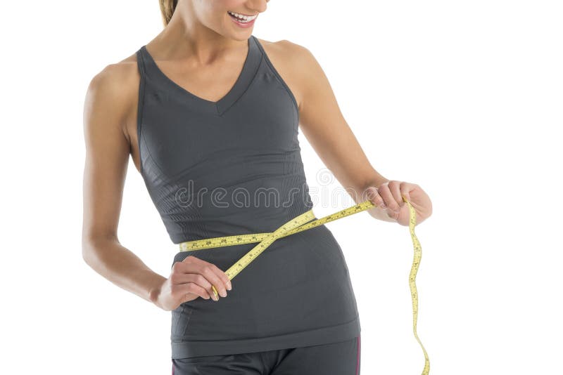 Midsection kobieta ono Uśmiecha się Podczas gdy Mierzący Jej talię zdjęcia stock Midsection kobieta ono Uśmiecha się Podczas gdy Mierzący Jej talię zdjęcia stock