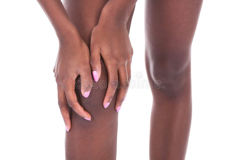 Midsection of African American woman suffering from knee pain against white background. Midsection of African American woman suffering from knee pain against white background