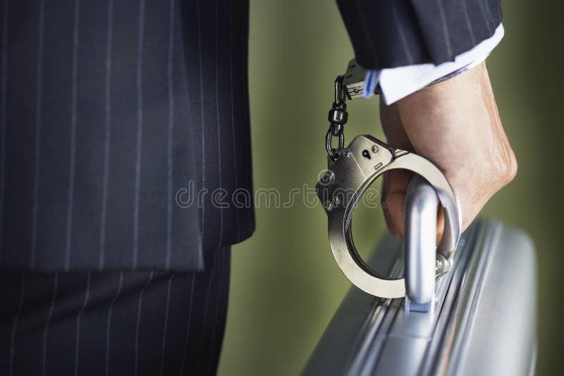 Closeup midsection of a businessman handcuffed to briefcase against green background. Closeup midsection of a businessman handcuffed to briefcase against green background
