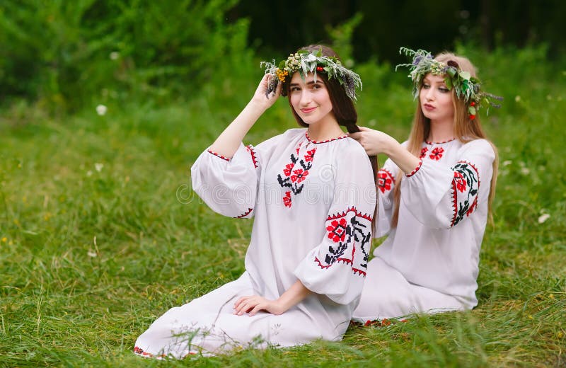 Midsummer. Two Girls in the Slavic Clothes Weave Braids in the Hair ...