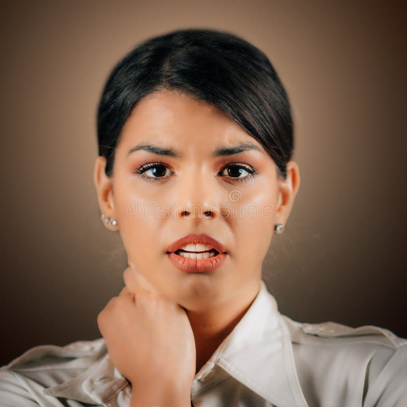 Miedo a las emociones. cara de una hermosa joven temerosa que expresa miedo estudio retrato fondo marrón fotografía de archivo