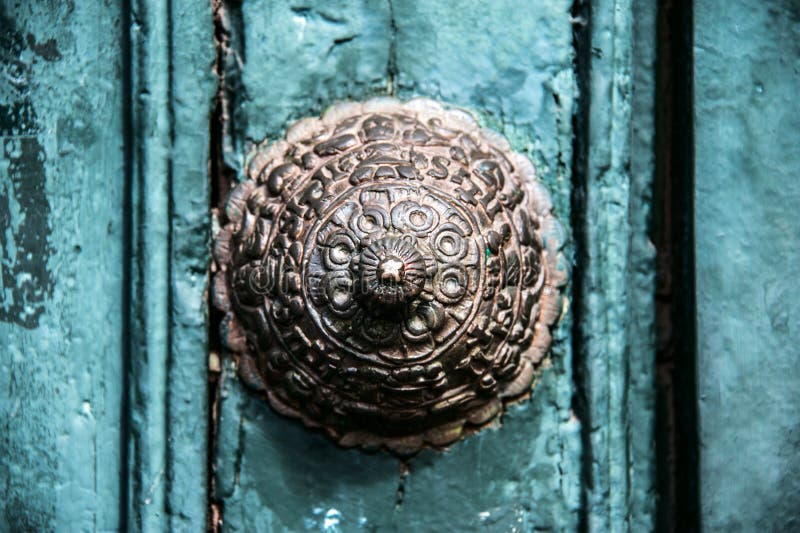 Miedziana dekoracja na starym drzwi w Cuzco
