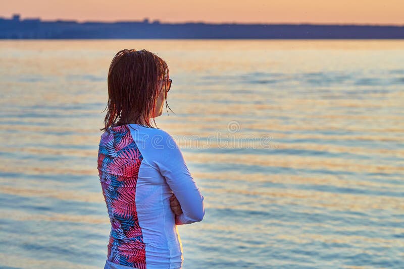 Miedzianowłosa, w średnim wieku kobieta po surfing klasy stojaków na brzeg jezioro, obrazy stock Miedzianowłosa, w średnim wieku kobieta po surfing klasy stojaków na brzeg jezioro, obrazy stock
