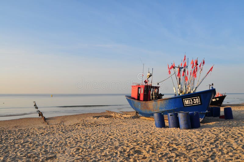 Miedzyzdroje Polen, November 2018: Grön fiskebåt på den sandiga stranden på Östersjön royaltyfri foto Miedzyzdroje Polen, November 2018: Grön fiskebåt på den sandiga stranden på Östersjön royaltyfri foto