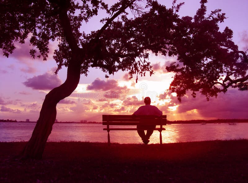 Silhouetted man on a bench enjoying a sunset. Silhouetted man on a bench enjoying a sunset