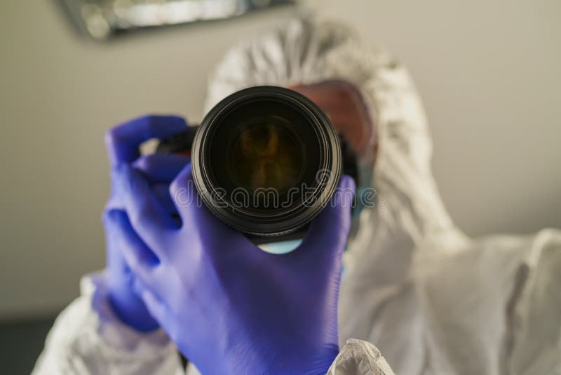 Miejsce przestępstwa medycyn sądowych oficer śledczy z cyfrową kamerą zdjęcie stock Miejsce przestępstwa medycyn sądowych oficer śledczy z cyfrową kamerą zdjęcie stock
