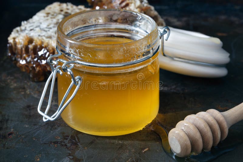 Miel dans le pot avec le nid d'abeilles et le drizzler en bois photo stock Miel dans le pot avec le nid d'abeilles et le drizzler en bois photo stock