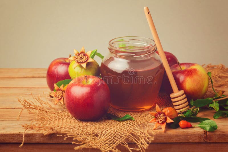 Miel, manzana y granada en la tabla de madera Efecto retro del filtro foto de archivo libre de regalías Miel, manzana y granada en la tabla de madera Efecto retro del filtro foto de archivo libre de regalías