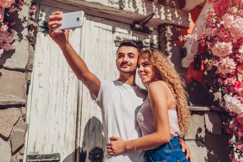 Mieszana biegowa para w miłości bierze selfie na smartphone odprowadzeniu w mieście Szczęśliwy arabski mężczyzna i biała kobieta zdjęcia royalty free Mieszana biegowa para w miłości bierze selfie na smartphone odprowadzeniu w mieście Szczęśliwy arabski mężczyzna i biała kobieta zdjęcia royalty free