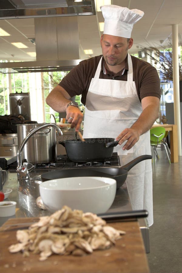 Italian chef stirring the food (shallow DOF, focus on chef). Italian chef stirring the food (shallow DOF, focus on chef)