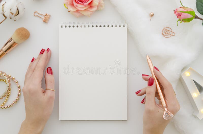 Mieszkanie nieatutowe żeńskie ręki z pięknym manicure'em piszą w notatniku z złocistym piórem na białym tle modny obrazy royalty free Mieszkanie nieatutowe żeńskie ręki z pięknym manicure'em piszą w notatniku z złocistym piórem na białym tle modny obrazy royalty free
