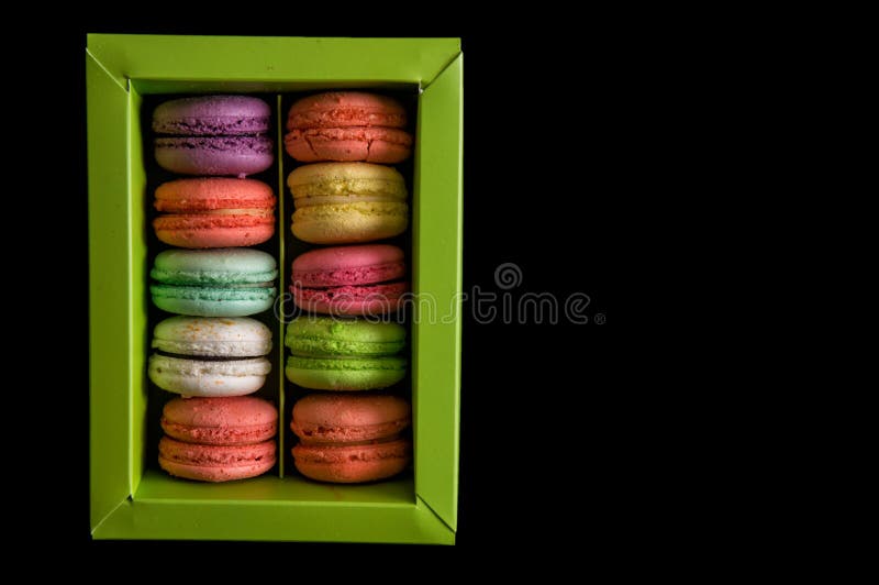 Mieszkanie nieatutowy z bliska Słodcy i kolorowi francuscy macarons ustawiający w jasnozielonym pudełku, odosobnionym na czarnym zdjęcia royalty free Mieszkanie nieatutowy z bliska Słodcy i kolorowi francuscy macarons ustawiający w jasnozielonym pudełku, odosobnionym na czarnym zdjęcia royalty free