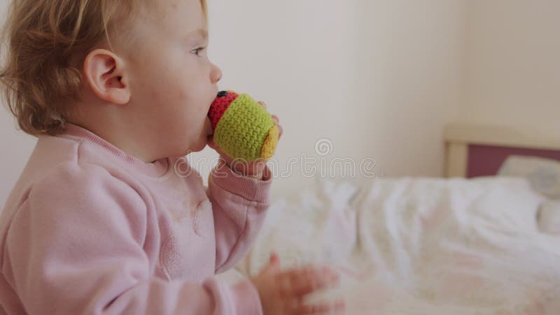 Mignon bébé assis sur un lit qui joue du roulement et rire clips vidéos