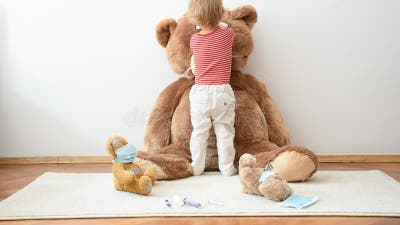 Drôle D'enfant Dans Un Masque Médical Joue Avec Un Ours En Peluche