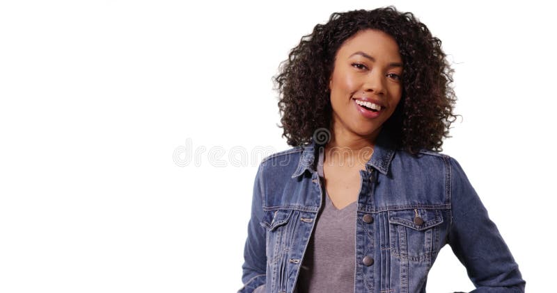 Mignonne femme africaine avec cheveux bouclés souriant à la caméra joyeusement en studio banque de vidéos