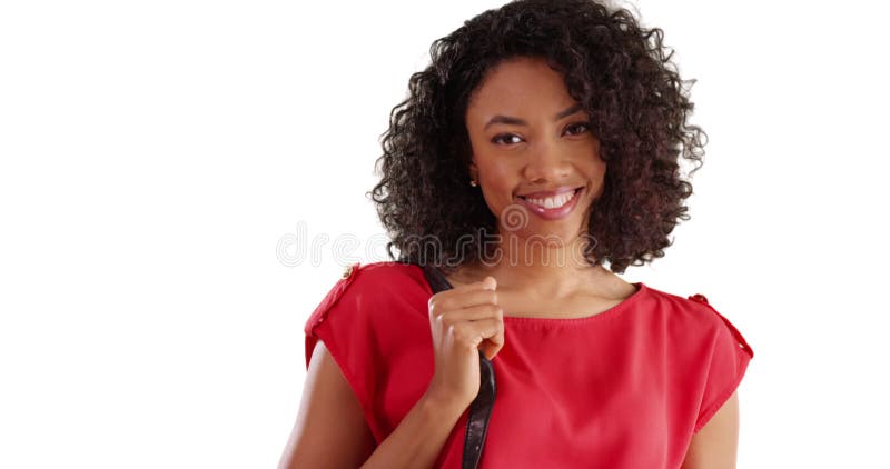 Mignonne femme africaine tenant son sac à main souriant à la caméra en studio avec copyspace banque de vidéos