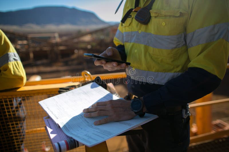 Mijnwerkerssupervisor die plaatsalarmnummer controleren v??r sigh van beperkte ruimtevergunning voorafgaand aan het uitvoeren van stock foto's Mijnwerkerssupervisor die plaatsalarmnummer controleren v??r sigh van beperkte ruimtevergunning voorafgaand aan het uitvoeren van stock foto's