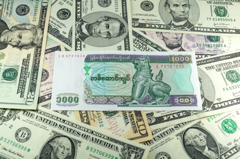 Mil kyats de myanmar en fondo de muchos dólares imagen de archivo libre de regalías Mil kyats de myanmar en fondo de muchos dólares imagen de archivo libre de regalías