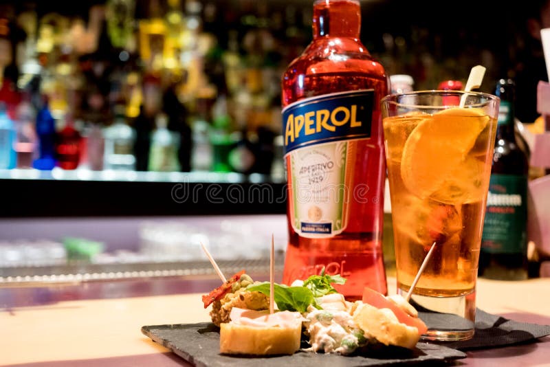 Milaan, Italië - 20 april 2019: fles van Italiaanse drankaperol spritz op barbovenkant met traditionele Italiaanse gelukkige uura stock afbeelding Milaan, Italië - 20 april 2019: fles van Italiaanse drankaperol spritz op barbovenkant met traditionele Italiaanse gelukkige uura stock afbeelding