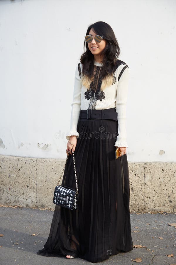 Woman poses for photographers with black and white dress and Hermes bag before Emilio Pucci fashion show