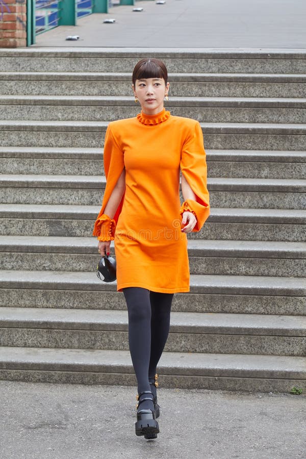 Woman with orange jacket and Balenciaga bag and man with Gucci bag before  John Richmond fashion show, Milan Fashion Week street style – Stock  Editorial Photo © AndreaA. #272373476