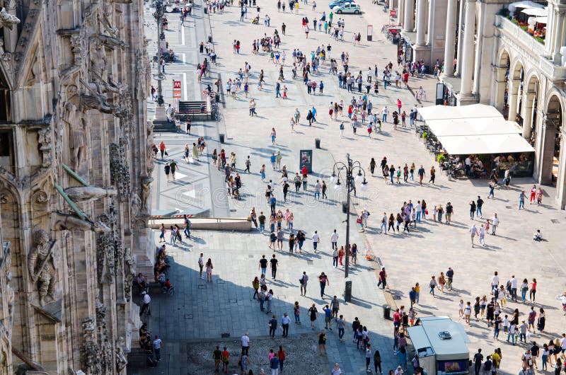 Milan, Italy, September 9, 2018: Crowd of small figures many people are walking on Piazza del Duomo square near Gallery Vittorio Emanuele II in historical city centre, top view from Milano cathedral. Milan, Italy, September 9, 2018: Crowd of small figures many people are walking on Piazza del Duomo square near Gallery Vittorio Emanuele II in historical city centre, top view from Milano cathedral