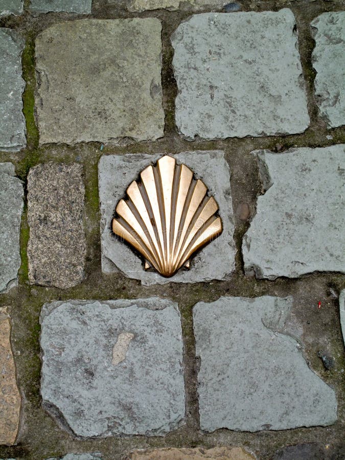 Milestone in shape of a shell inserted in the pavement stock images