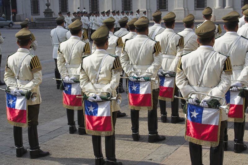 Military band in a parade in front of Palacio de La Moneda, Santiago de Chile downwtown. The players are holding the flag of the country and a trumpet. They are at the change of the guard. Military band in a parade in front of Palacio de La Moneda, Santiago de Chile downwtown. The players are holding the flag of the country and a trumpet. They are at the change of the guard.