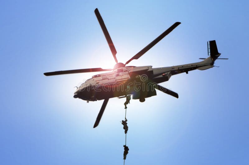 Military commando helicopter drops under bright daylight royalty free stock images