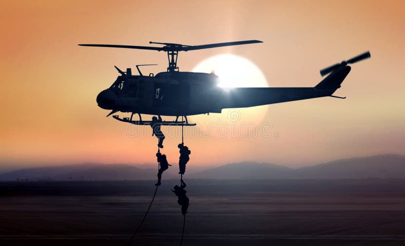 Military commandos helicopter drops during sunrise royalty free stock photo