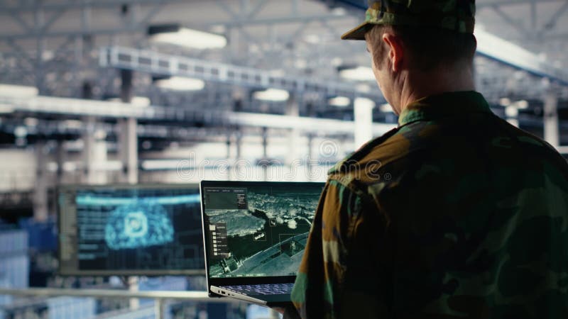 Military engineer in data center tracking satellite coordinates using laptop stock footage