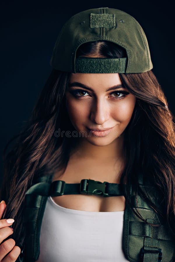 Military fashion. Close up portrait of beautiful brunette woman looking at the camera on a black background. Attractive girl royalty free stock image Military fashion. Close up portrait of beautiful brunette woman looking at the camera on a black background. Attractive girl royalty free stock image