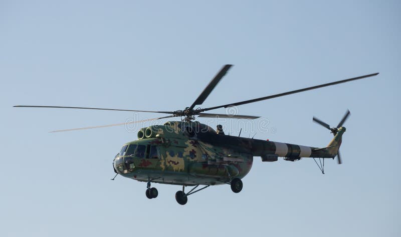 The military helicopter against the blue sky