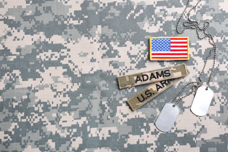 Military ID Tags And US Army Patches On Camouflage Background, Flat Lay