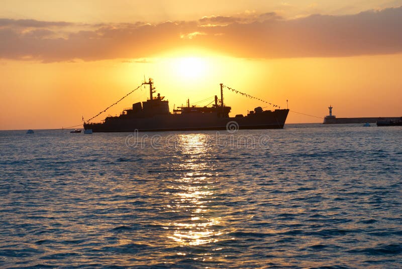 Military ship against sunset stock photography