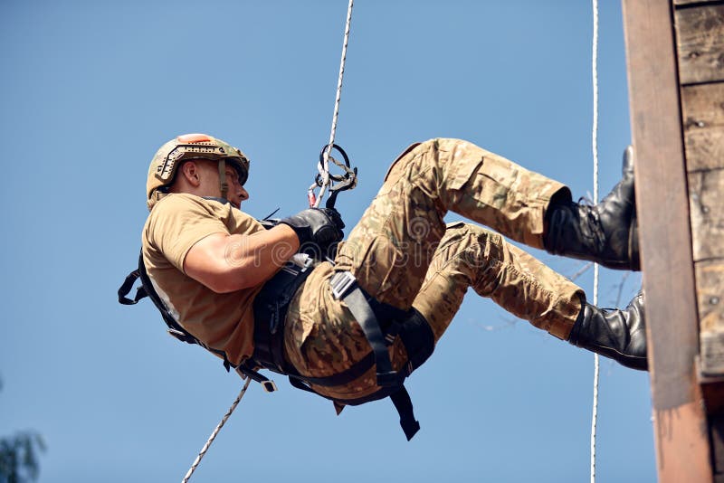 Military Soldier Climbing Net during Obstacle Course in Boot Camp Stock