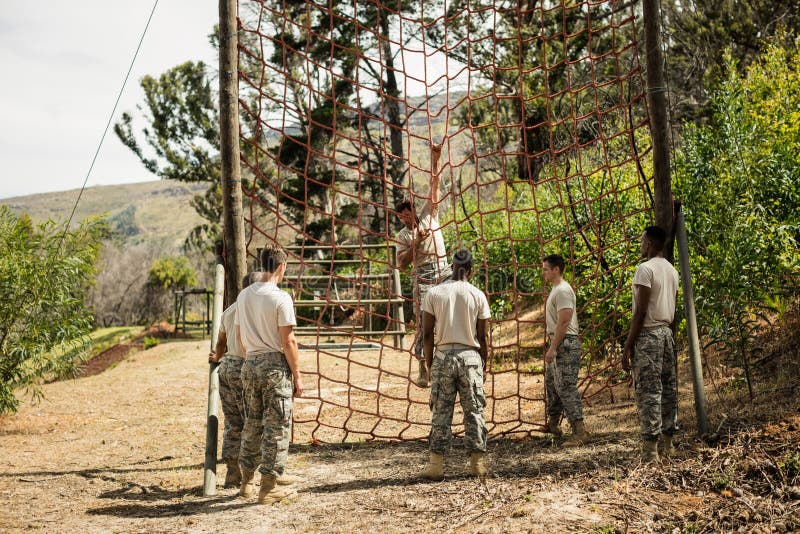 Military Soldier Climbing Rope During Obstacle Course Stock Image