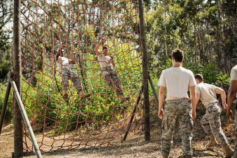 Military Soldiers Climbing Rope during Obstacle Course Stock Image